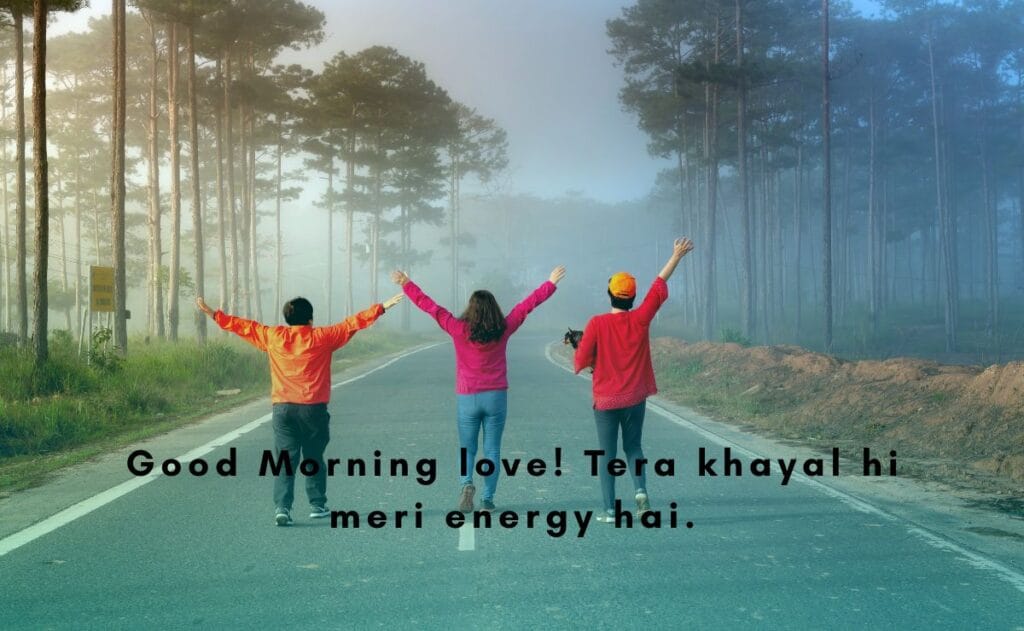 Three people with raised arms joyfully walk on a foggy forest road.