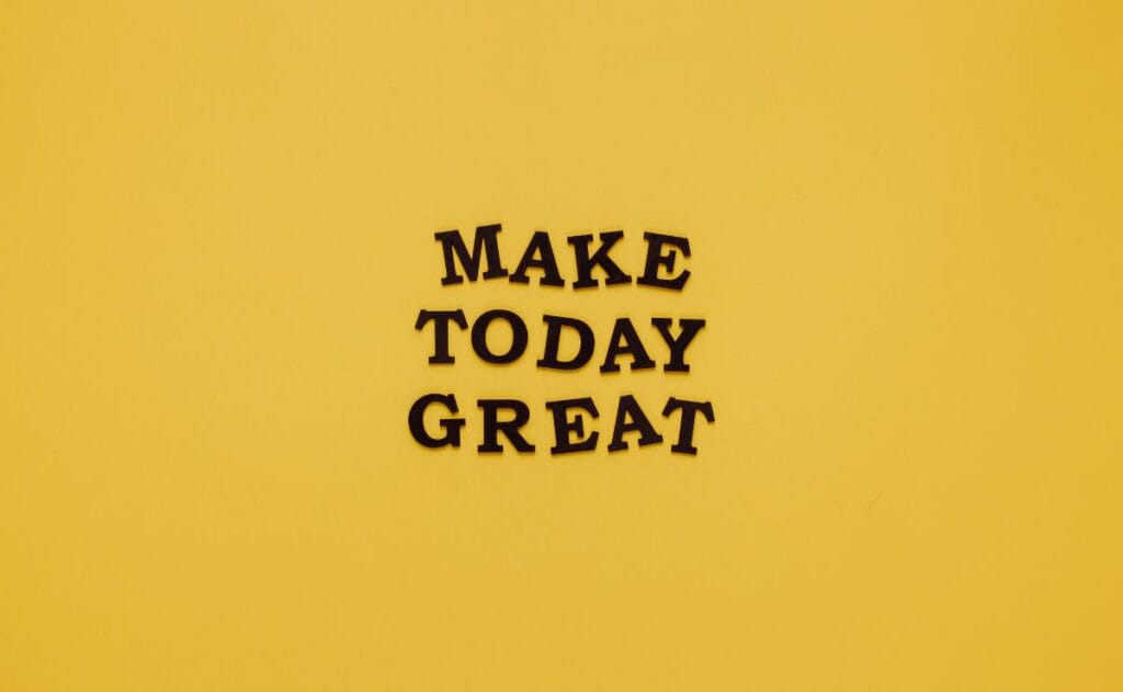 Black text on a bright yellow background reads "MAKE TODAY GREAT" in a cheerful and motivational style. The tone is positive and uplifting.